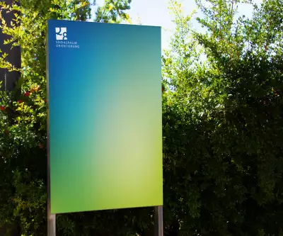 Ein großes Schild mit grünem und blauem Farbverlauf und dem Logo von Q8.