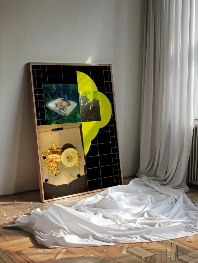 Ein großformatiges Kunstwerk leaning gegen eine helle Wand zeigt ein abstraktes Collage-Design mit geometrischen Formen, gelben organischen Elementen und fotografischen Fragmenten auf schwarzem Hintergrund. Weiße Stoffbahnen liegen zusammengefaltet vor dem Werk auf dem Holzboden. Rechts im Bild sind vertikale weiße Vorhänge zu sehen.