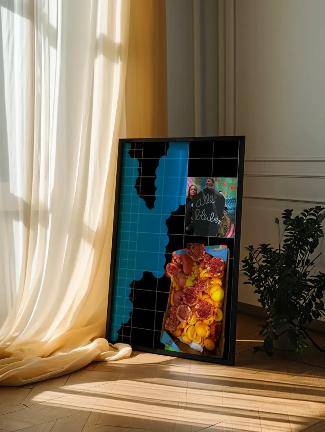 Ein großformatiges schwarzes Kunstwerk mit blauen und bunten Elementen lehnt an einer Wand neben transparenten Vorhängen und einer grünen Pflanze. Das Werk besteht aus mehreren Bildschirmen oder Paneelen, die teilweise mit abstrakten Formen und fotografischen Aufnahmen gestaltet sind. Sonnenlicht wirft Schatten auf den hellen Holzboden und die beige Wandfläche.