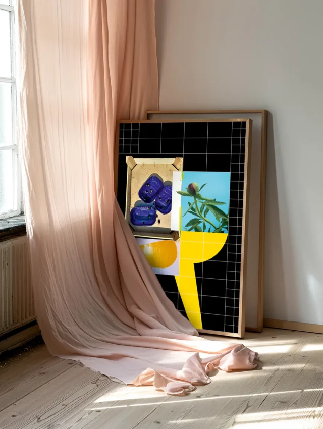 Ein Kunstwerk mit schwarzem Gitterrahmen lehnt an einer weißen Wand neben einem Fenster mit rosa Vorhang. Das Werk zeigt bunte geometrische Formen und fotografische Elemente in Blau, Gelb und Orange sowie Bilder von Blüten und Pflanzen. Sonnenlicht wirft Schatten auf den hellen Holzboden.