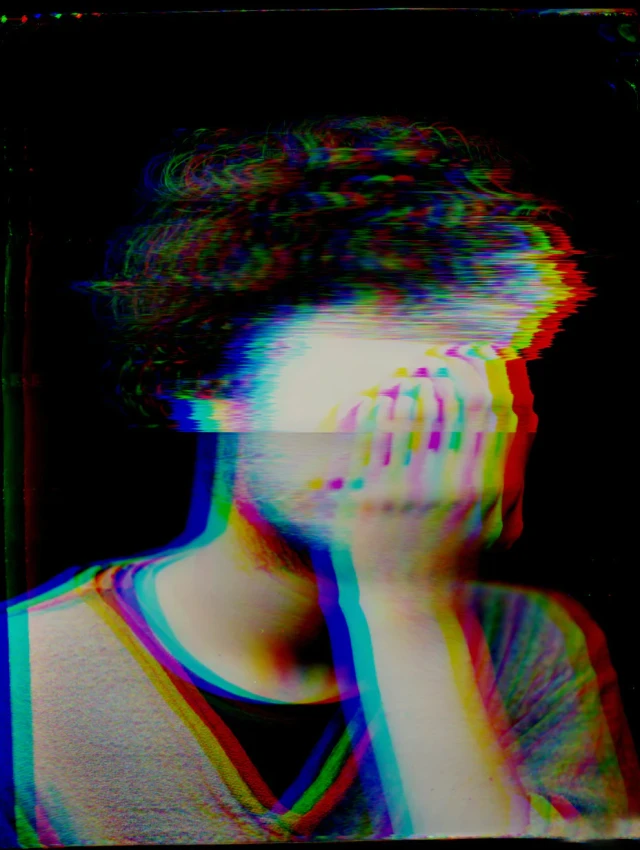 Eine Person mit kurzen Haaren blickt nach oben, mit chromatic aberration Effekt in Rot, Grün und Blau. Das Porträt hat eine digitale Glitch-Ästhetik mit überlagerten Farbkanälen auf schwarzem Hintergrund.
