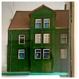 ein Haus in dem Schaufenster des Antiquitätengeschäftes von Rainer Mauersberg in Nienburg in der Bisquitstraße 2